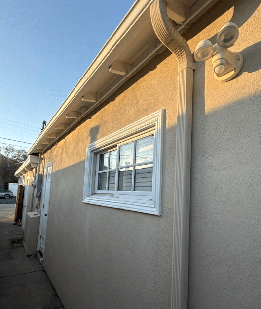 Stucco exterior with gutter and downspout by McCarthy Painting